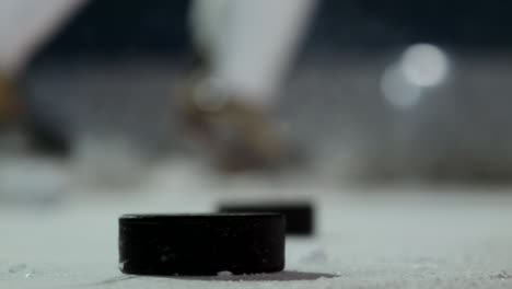 Nahaufnahme-Des-Pucks-Auf-Dem-Eis-Und-Der-Hockeyspieler-Schlägt-Den-Puck-In-Zeitlupe